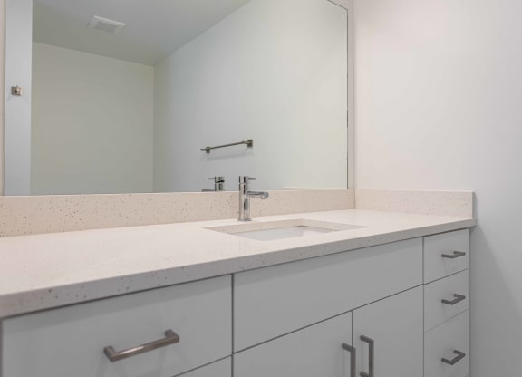 a white bathroom with a sink and a mirror