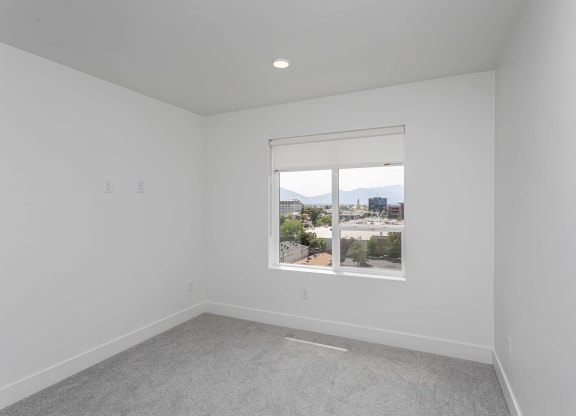 an empty room with a window overlooking a city