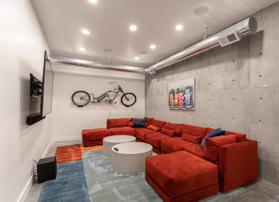 a living room with a red couch and a bike on the wall