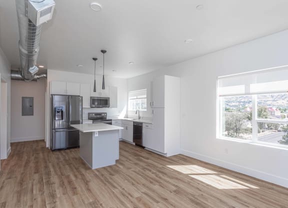 an empty kitchen with white walls and wood floors