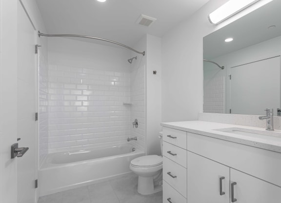 a white bathroom with a tub and a sink and a toilet