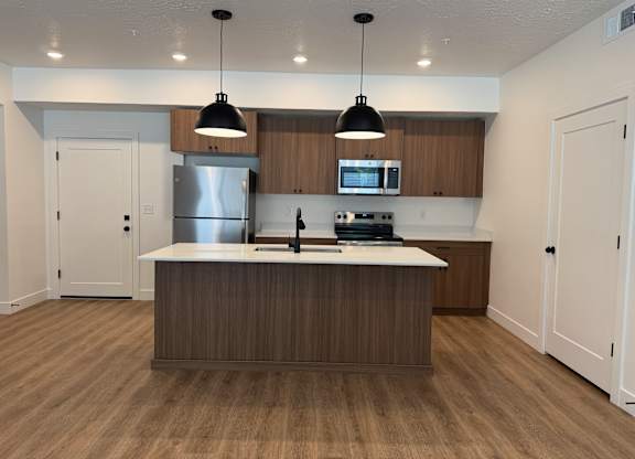 A modern kitchen with wooden cabinets and a center island.