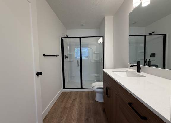 A bathroom with a toilet, sink, and shower.