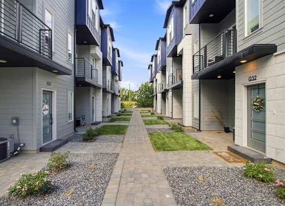 A long, narrow walkway separates apartment buildings.