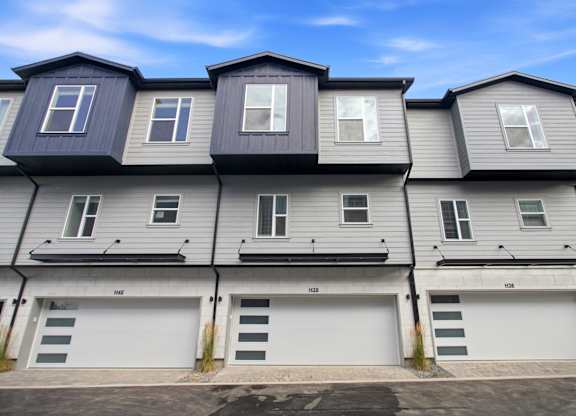 A row of houses with garages on the ground floor.