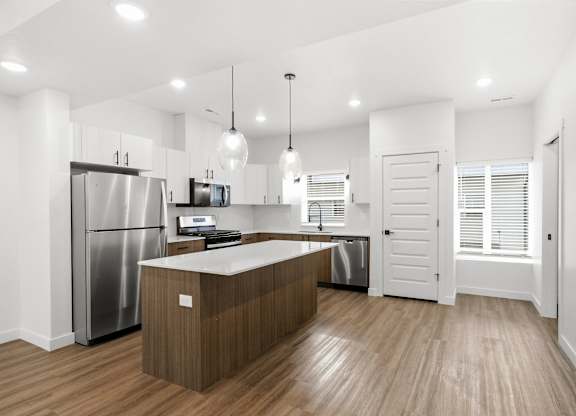 A modern kitchen with a wooden island and stainless steel appliances.