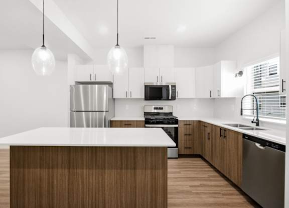 A modern kitchen with a wooden island and stainless steel appliances.