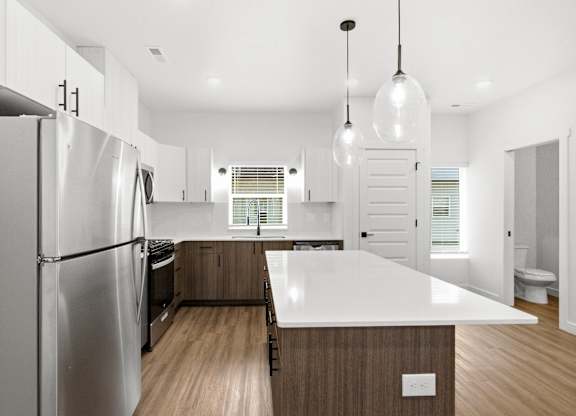 A modern kitchen with a large island and stainless steel appliances.
