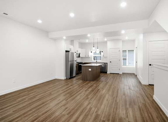 A kitchen with wooden floors and white walls.