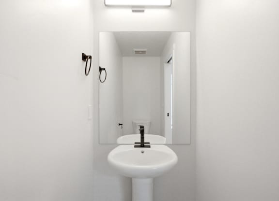 A white sink in a white bathroom.