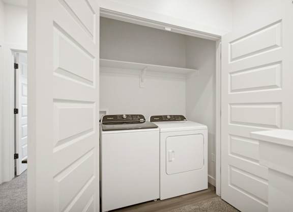 A white laundry room with a washer and dryer.