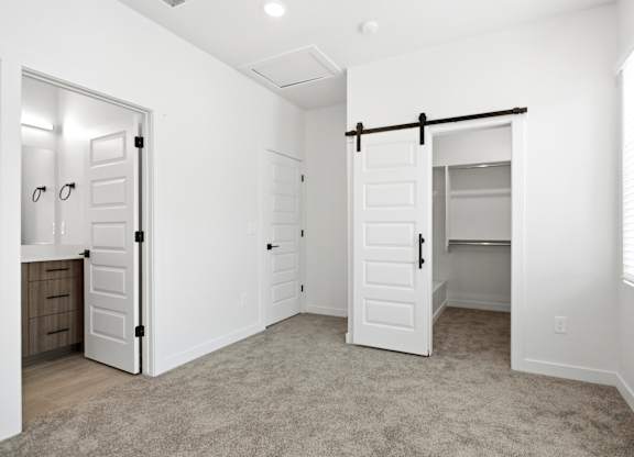 A white room with a carpeted floor and a sliding door.