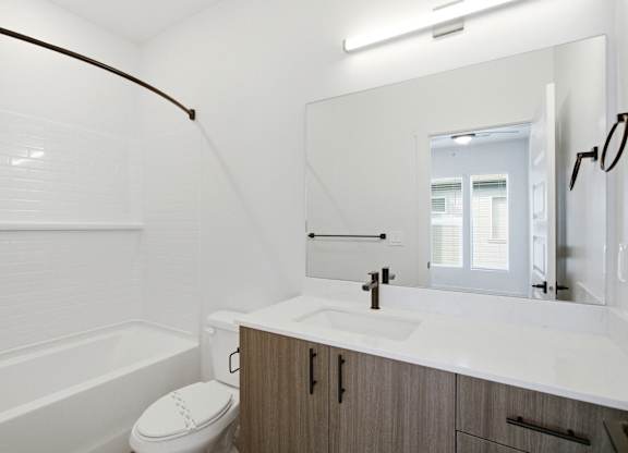 A white bathroom with a toilet, sink, and bathtub.