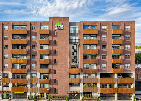 a large apartment building with a green logo on the side of it