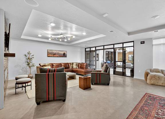 A living room with a brown sofa and a red rug.
