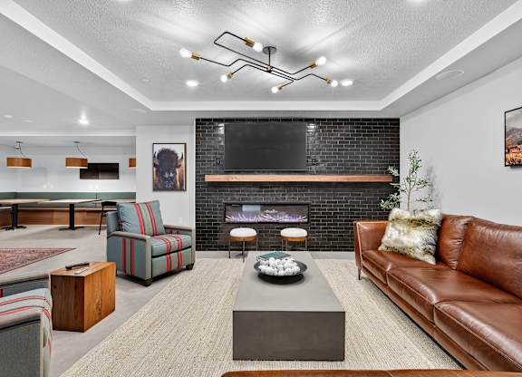 A modern living room with a fireplace and a flat screen TV mounted above it.