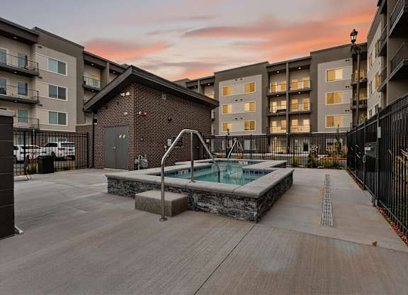 A pool surrounded by a black fence in a courtyard.