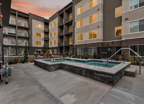 A swimming pool in a courtyard surrounded by apartment buildings.