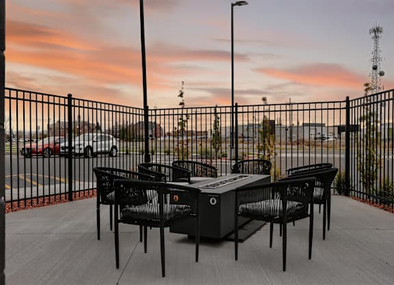 A table and chairs set on a patio overlooking a parking lot.