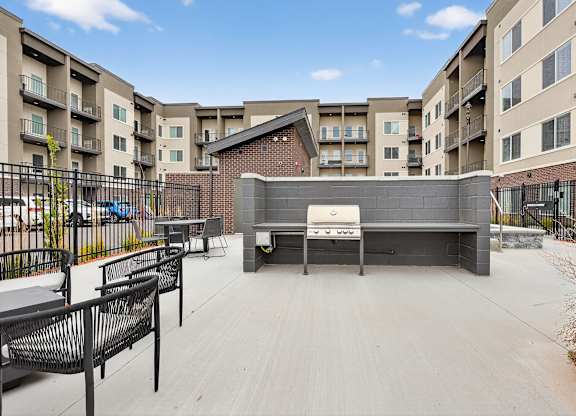 A black metal fence surrounds a patio with a table and chairs.