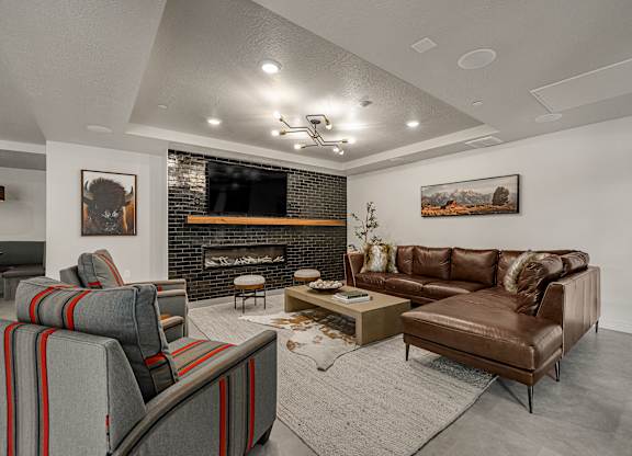 A living room with a fireplace and a brown couch.
