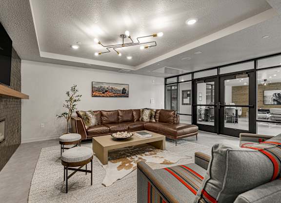 A modern living room with a fireplace and a large brown sofa.