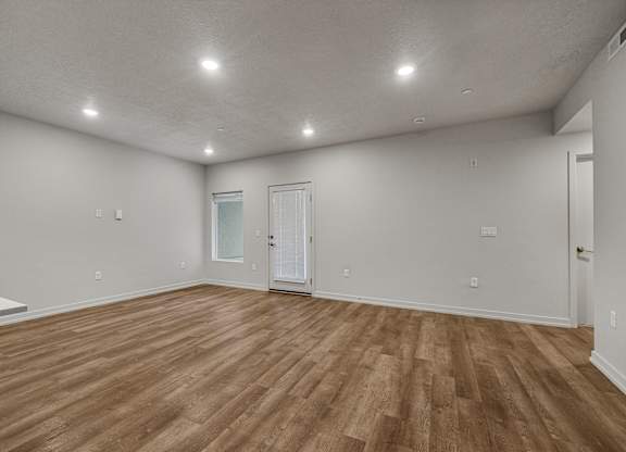 A room with wooden flooring and white walls.