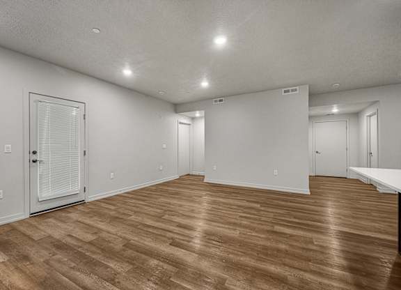 A room with wooden flooring and white walls.