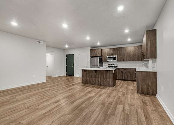 A kitchen with wooden floors and cabinets.