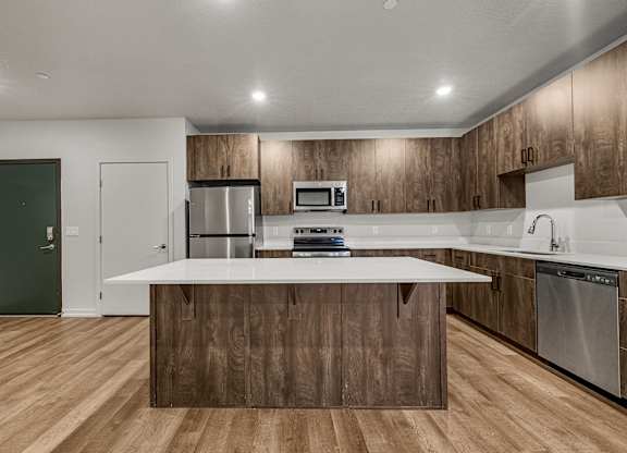 A modern kitchen with wooden cabinets and stainless steel appliances.