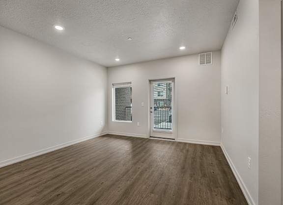 A room with a wooden floor and a glass door.
