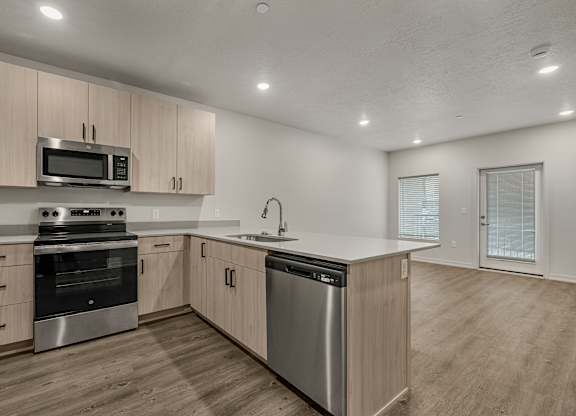 A modern kitchen with stainless steel appliances and wooden cabinets.