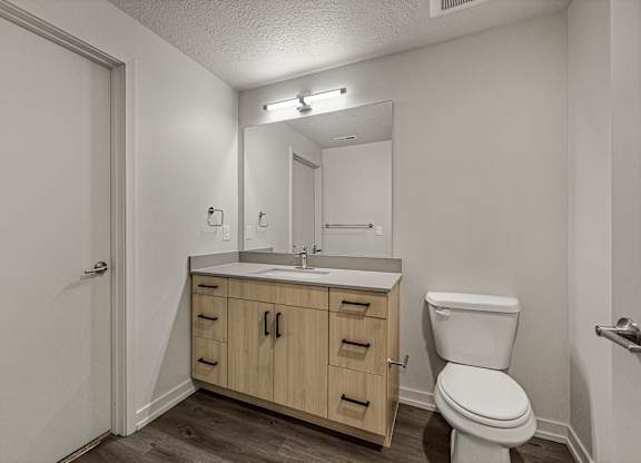 A bathroom with a toilet, sink, and medicine cabinet.