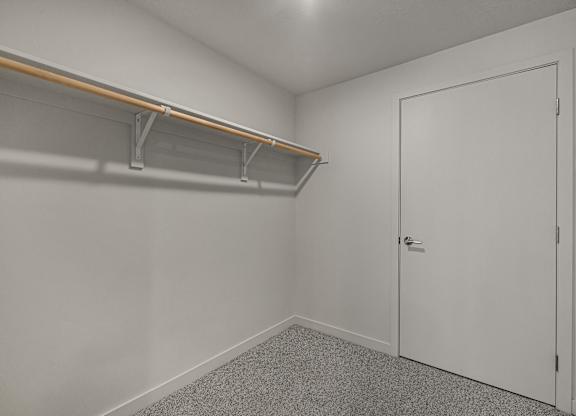 A white door is closed in a room with a grey carpet.