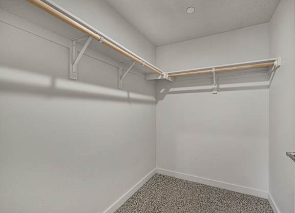 A white room with a shelf and a door.