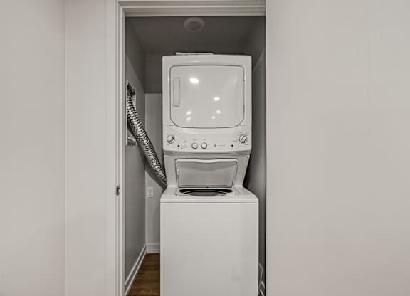 A white washing machine is in a small alcove.