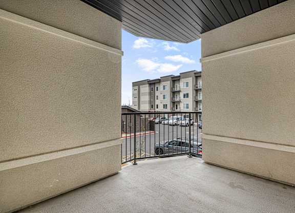 A view from inside a building looking out to a parking lot and other buildings.