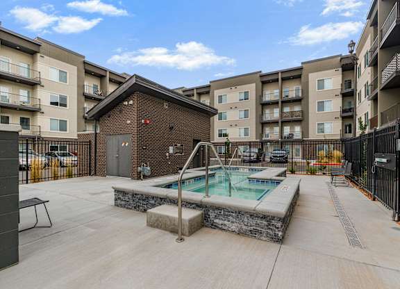 A pool in a courtyard surrounded by buildings.