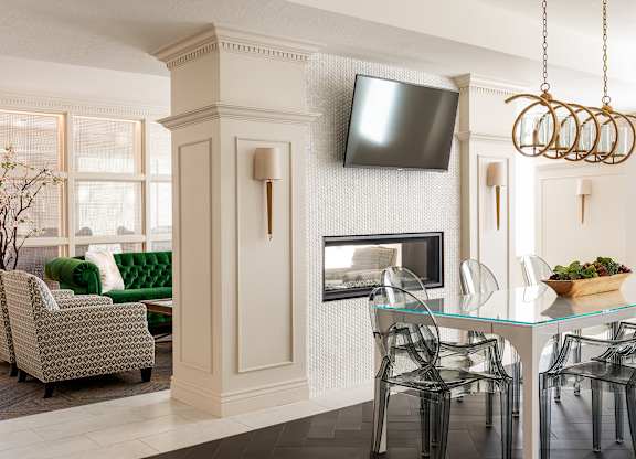 A living room with a fireplace, a television, and a dining table set for four.