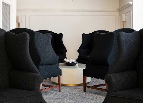 Two black chairs facing each other with a table in between.