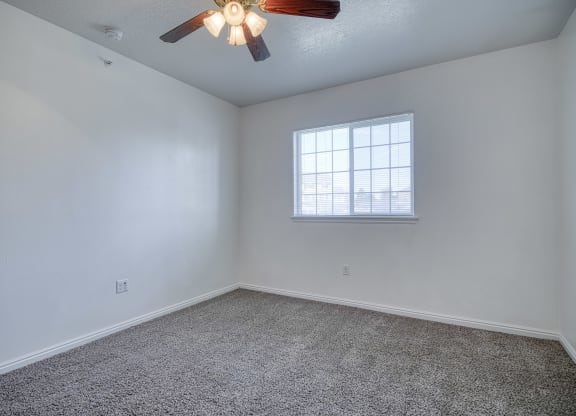 a bedroom with a ceiling fan and a window
