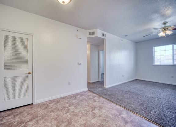 a bedroom with a ceiling fan and carpet