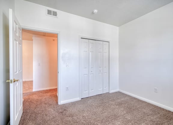 a bedroom with white walls and carpet