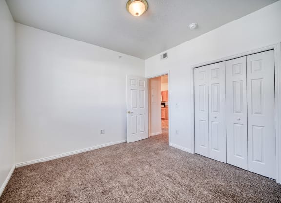a bedroom with white walls and carpet