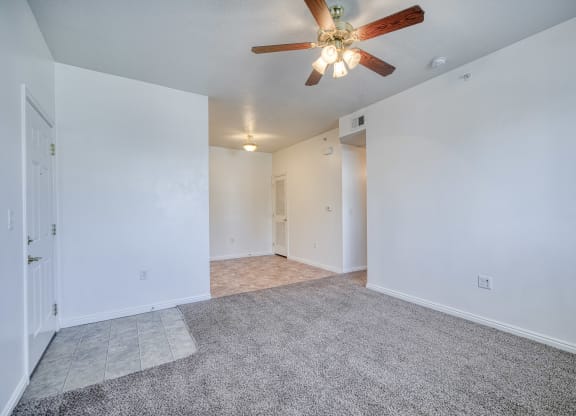 a bedroom with white walls and a ceiling fan