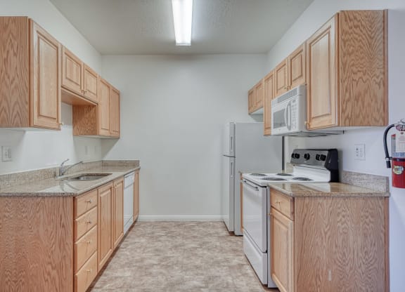 a kitchen with wood cabinets and white appliances