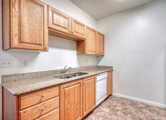 a kitchen with wooden cabinets and a white dishwasher