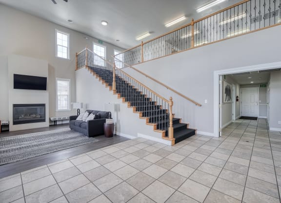 a spacious living room with a staircase leading up to the second floor