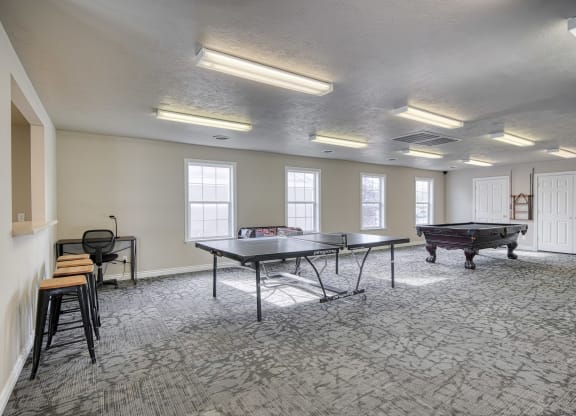a games room with two ping pong tables and a foosball table