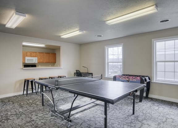 a room with a ping pong table and a couch